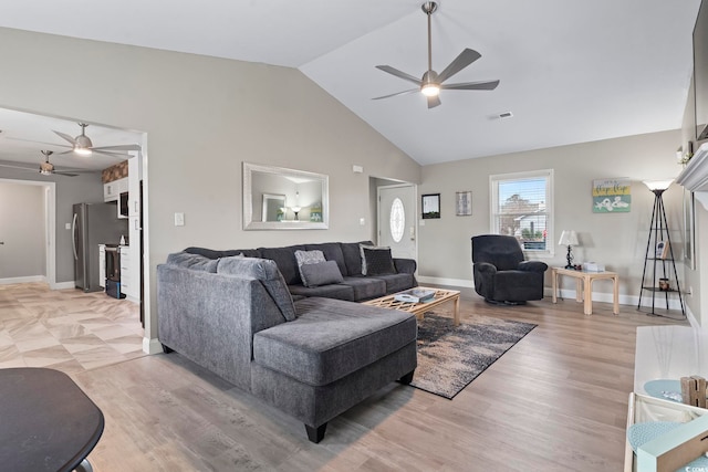 living room featuring ceiling fan, vaulted ceiling, and light hardwood / wood-style flooring