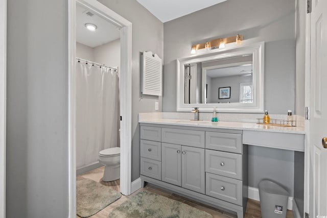 bathroom featuring toilet, a shower with curtain, and vanity