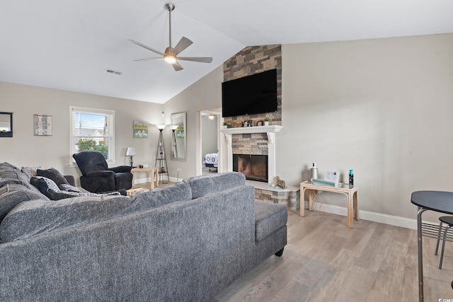 living room featuring vaulted ceiling, ceiling fan, a fireplace, and hardwood / wood-style flooring