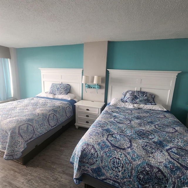 bedroom with a textured ceiling and dark hardwood / wood-style floors