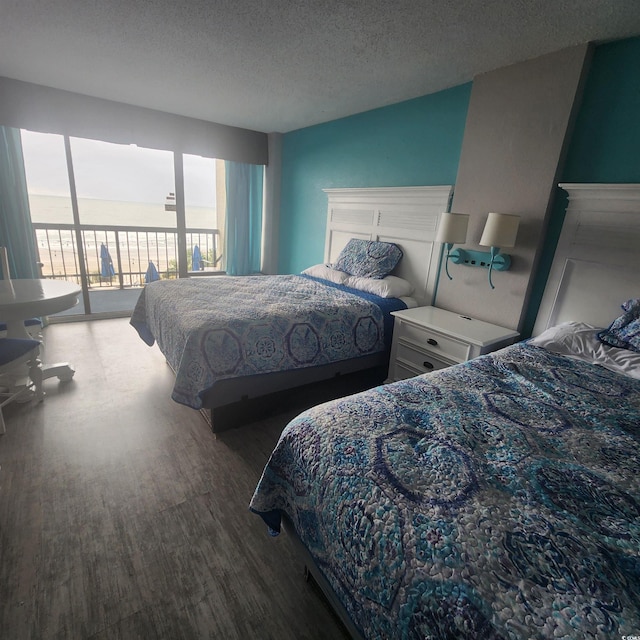 bedroom featuring a textured ceiling, dark wood-type flooring, and access to exterior