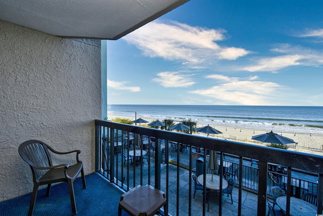 balcony with a water view and a beach view