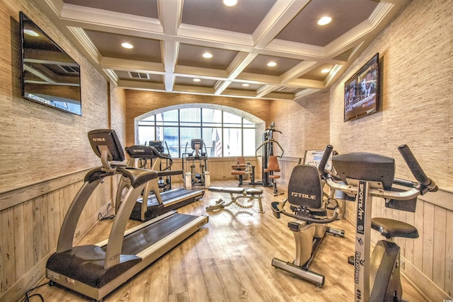 workout area featuring hardwood / wood-style floors, crown molding, wood walls, and coffered ceiling