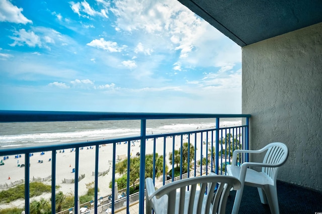 balcony featuring a view of the beach and a water view