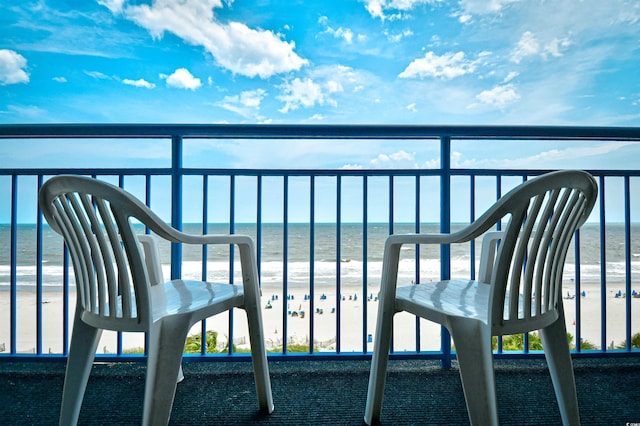 balcony featuring a beach view and a water view