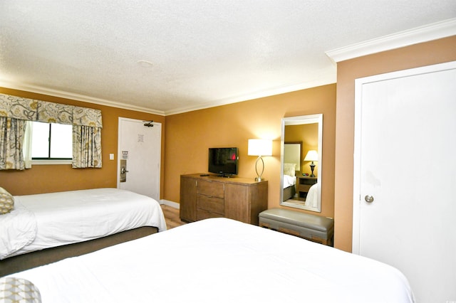 bedroom with a textured ceiling and ornamental molding