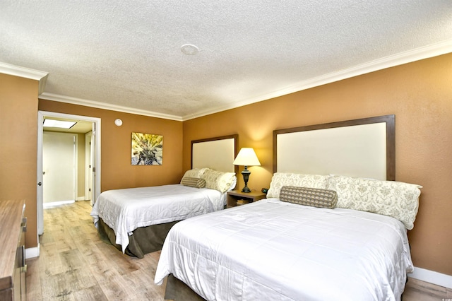 bedroom featuring a textured ceiling, ornamental molding, and light hardwood / wood-style floors