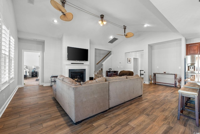 living room featuring vaulted ceiling, dark hardwood / wood-style floors, and ceiling fan