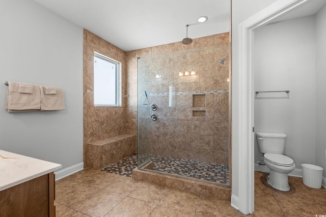 bathroom with vanity, a tile shower, and toilet