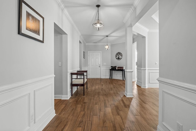 hallway featuring dark wood-type flooring, ornamental molding, and ornate columns