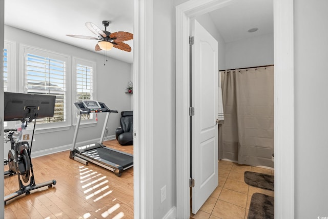 exercise room with light tile patterned floors and ceiling fan