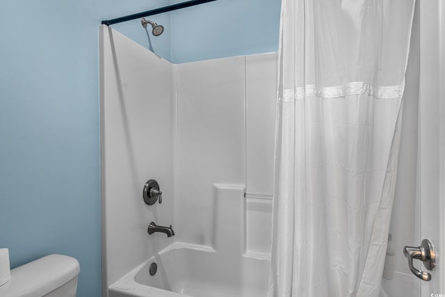 bathroom featuring shower / tub combo and toilet