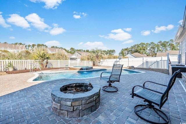 view of swimming pool featuring an in ground hot tub, a patio, and an outdoor fire pit