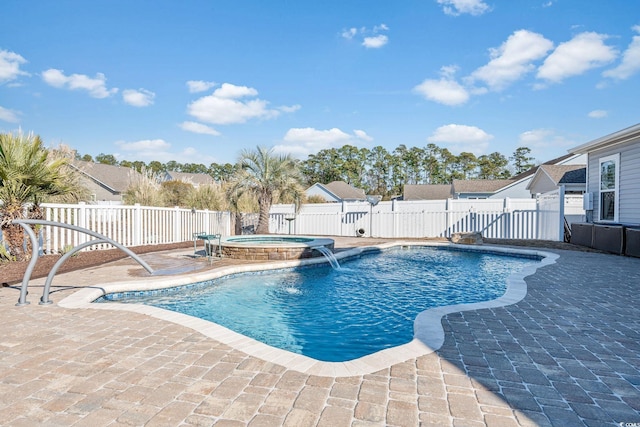 view of pool with an in ground hot tub, pool water feature, and a patio area