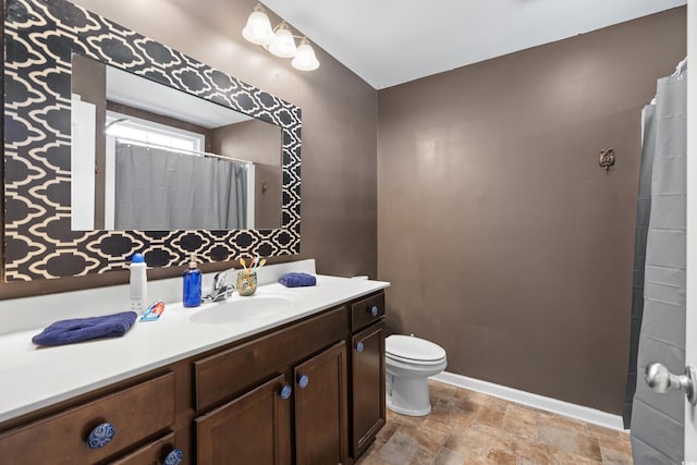 bathroom featuring vanity, toilet, and curtained shower