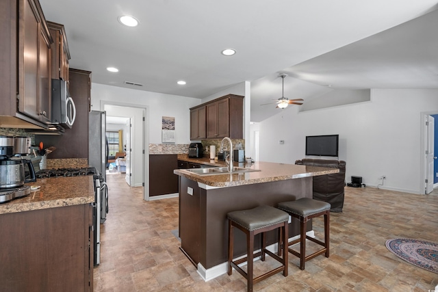 kitchen featuring tasteful backsplash, sink, ceiling fan, kitchen peninsula, and stainless steel appliances