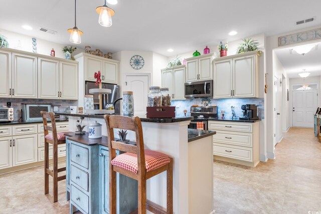 kitchen featuring decorative light fixtures, backsplash, an island with sink, a kitchen breakfast bar, and stainless steel appliances