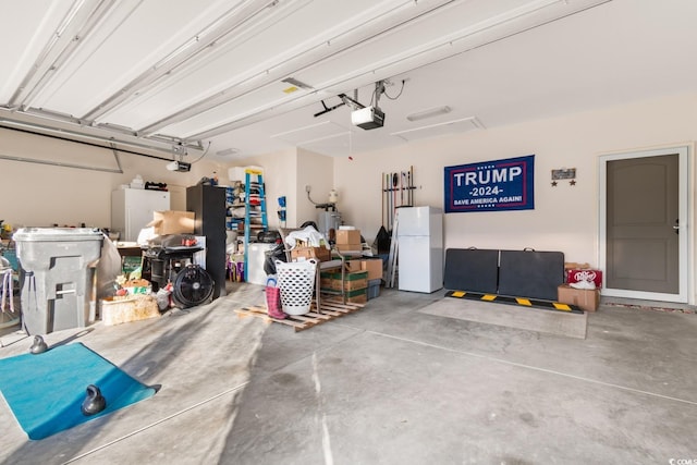 garage featuring a garage door opener and white refrigerator