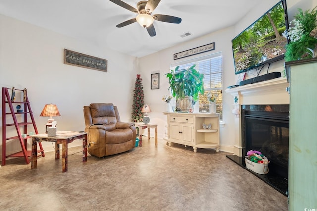 living area with ceiling fan and concrete flooring