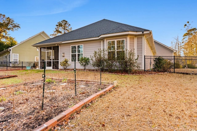 rear view of house with a sunroom and a lawn