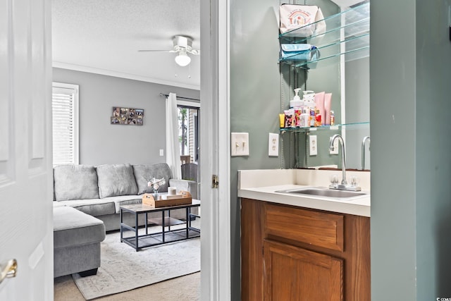 bathroom featuring ceiling fan, a textured ceiling, vanity, and ornamental molding