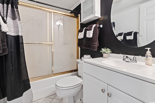 full bathroom with a textured ceiling, tile patterned floors, vanity, toilet, and combined bath / shower with glass door