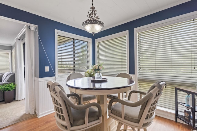 dining room with light wood-type flooring and crown molding