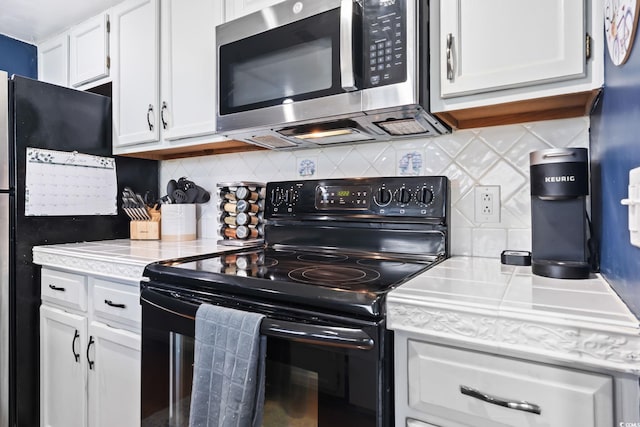 kitchen with backsplash, white cabinets, and black appliances