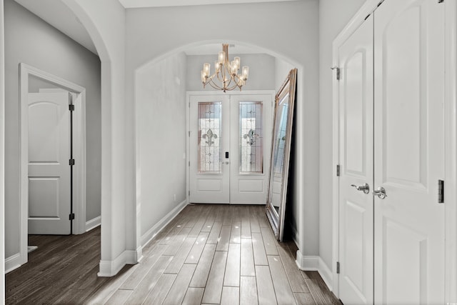 entrance foyer with a chandelier, dark hardwood / wood-style flooring, and french doors