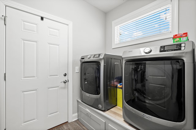 laundry room with hardwood / wood-style flooring and washer and clothes dryer