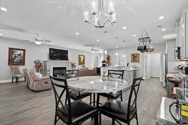 dining room with ceiling fan, sink, and light hardwood / wood-style floors