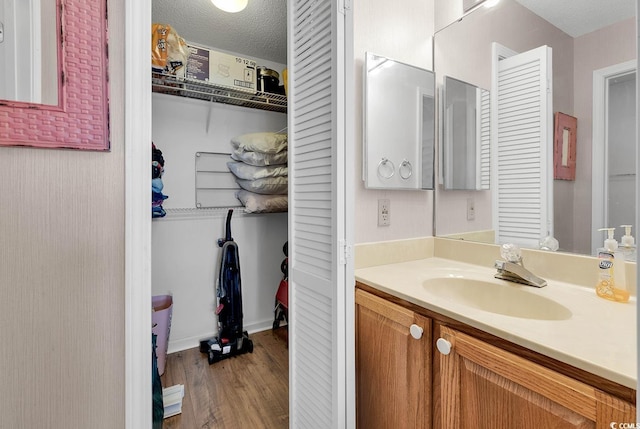 bathroom featuring vanity, hardwood / wood-style floors, and a textured ceiling