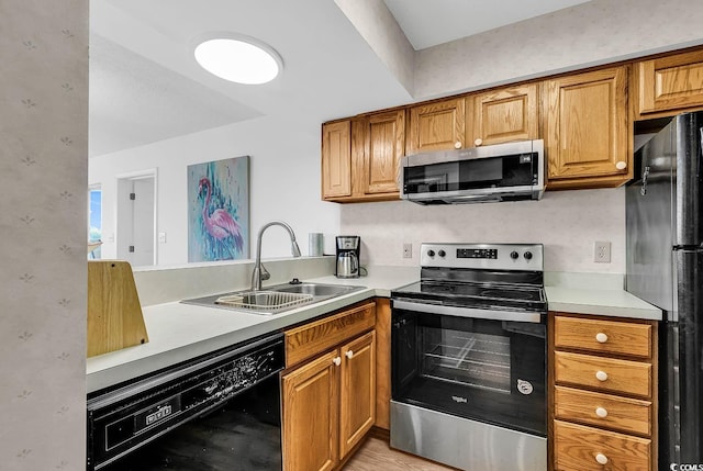 kitchen with kitchen peninsula, sink, and black appliances