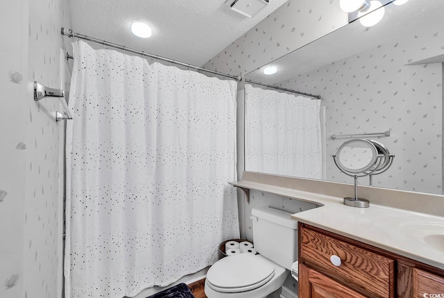 bathroom with vanity, a textured ceiling, and toilet