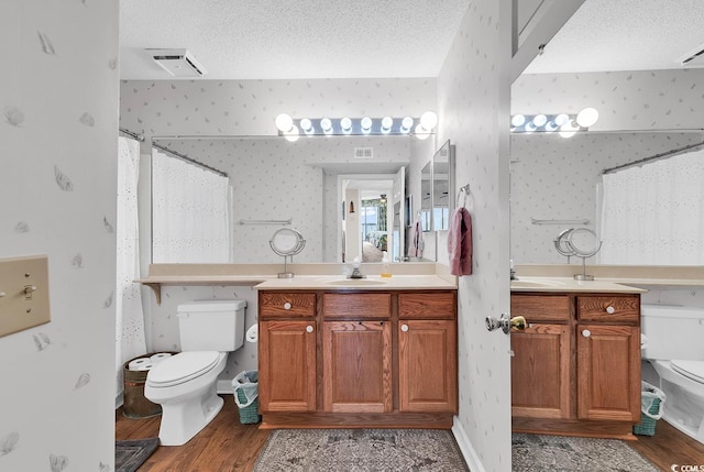 4560 Greenbriar Dr Unit 102-B, Little River, SC 29566 - bathroom featuring toilet, a textured ceiling, wallpapered walls, and wood finished floors