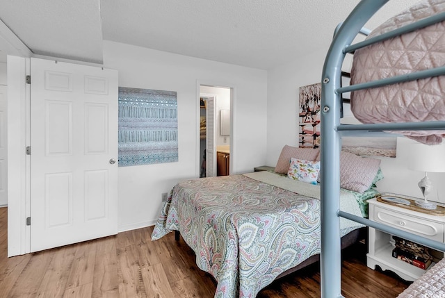 bedroom with hardwood / wood-style floors and a textured ceiling