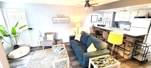 living room featuring ceiling fan and dark wood-style floors