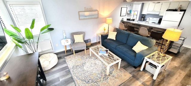 living area featuring baseboards and dark wood-style flooring