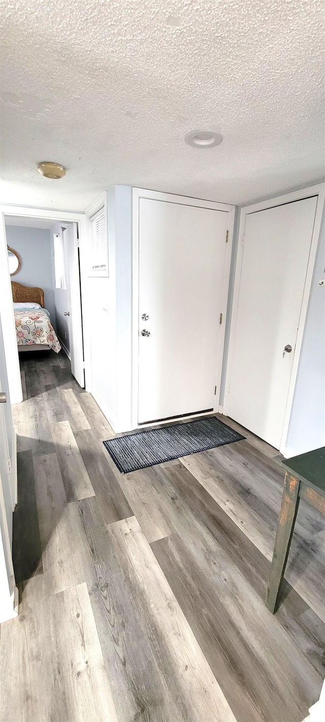 interior space with a textured ceiling and wood finished floors