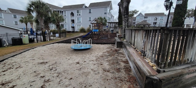 communal playground featuring a residential view and fence