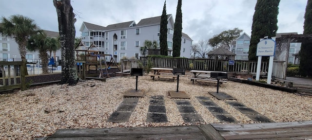 view of home's community with a residential view, fence, and playground community