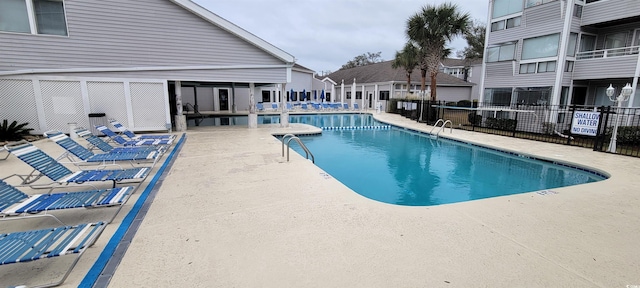 community pool featuring a patio area and fence