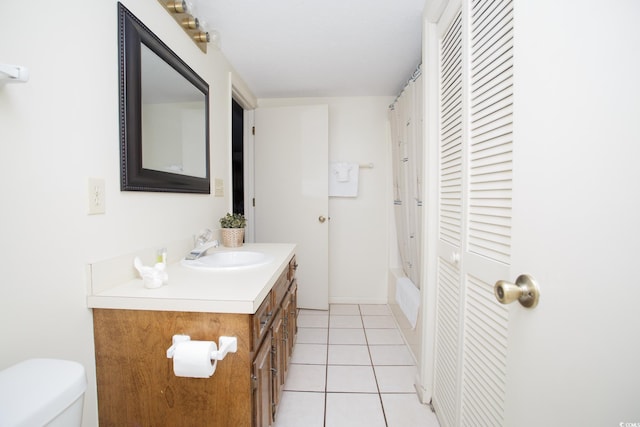 full bathroom with shower / bath combination with curtain, vanity, tile patterned floors, and toilet