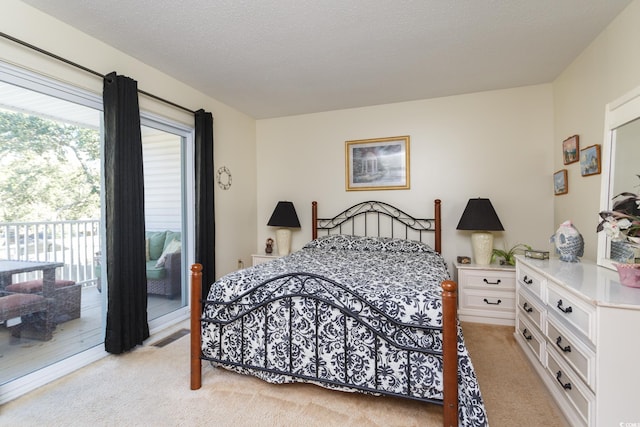 carpeted bedroom with access to outside and a textured ceiling