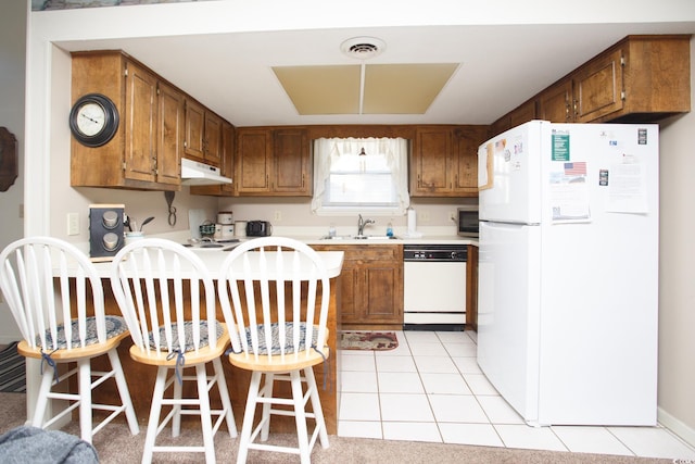 kitchen featuring sink, white appliances, and light tile patterned floors