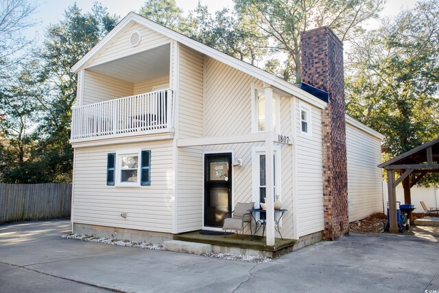 view of front of house with a balcony, a patio area, and a gazebo