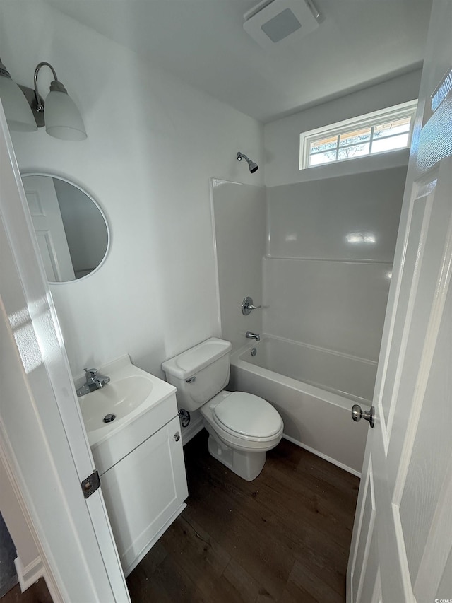 bathroom featuring toilet, bathtub / shower combination, wood finished floors, and vanity