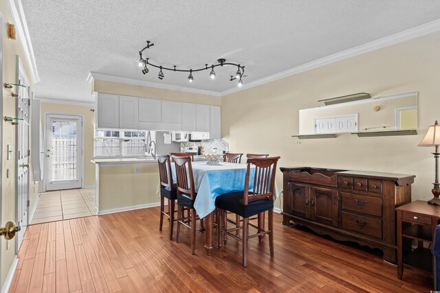618 3rd Ave S Unit 4D, North Myrtle Beach, SC 29582 - dining space featuring crown molding, light wood finished floors, baseboards, and a textured ceiling