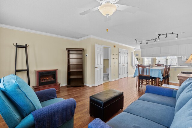 618 3rd Ave S Unit 4D, North Myrtle Beach, SC 29582 - living area with ornamental molding, wood finished floors, a ceiling fan, a warm lit fireplace, and baseboards