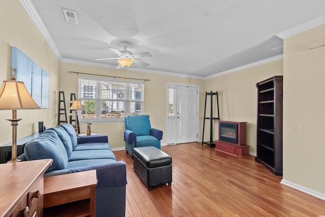 618 3rd Ave S Unit 4D, North Myrtle Beach, SC 29582 - living room featuring light wood-style flooring, a ceiling fan, a textured ceiling, ornamental molding, and baseboards